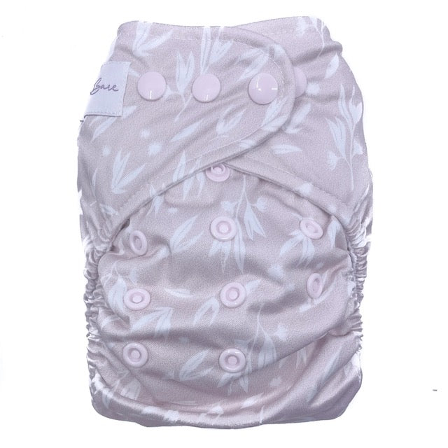 A reusable cloth nappy with a blossom print on a pink base