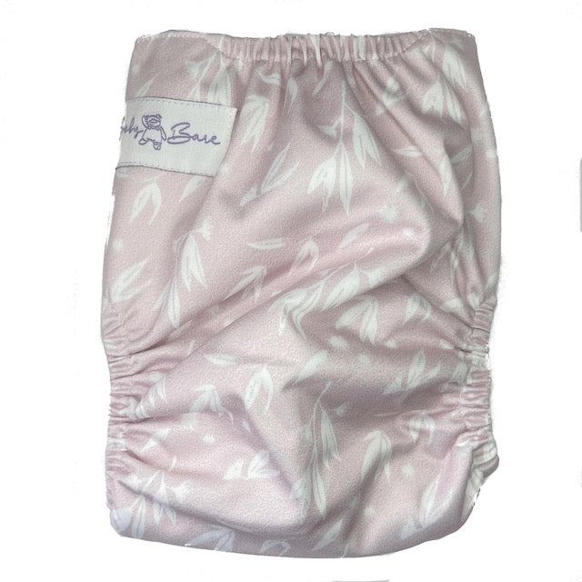 A reusable cloth nappy with a blossom print on a pink base