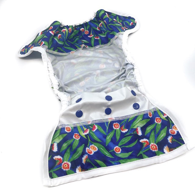 The inside of a Baby Bare nappy wrap cover featuring navy blue snap closures