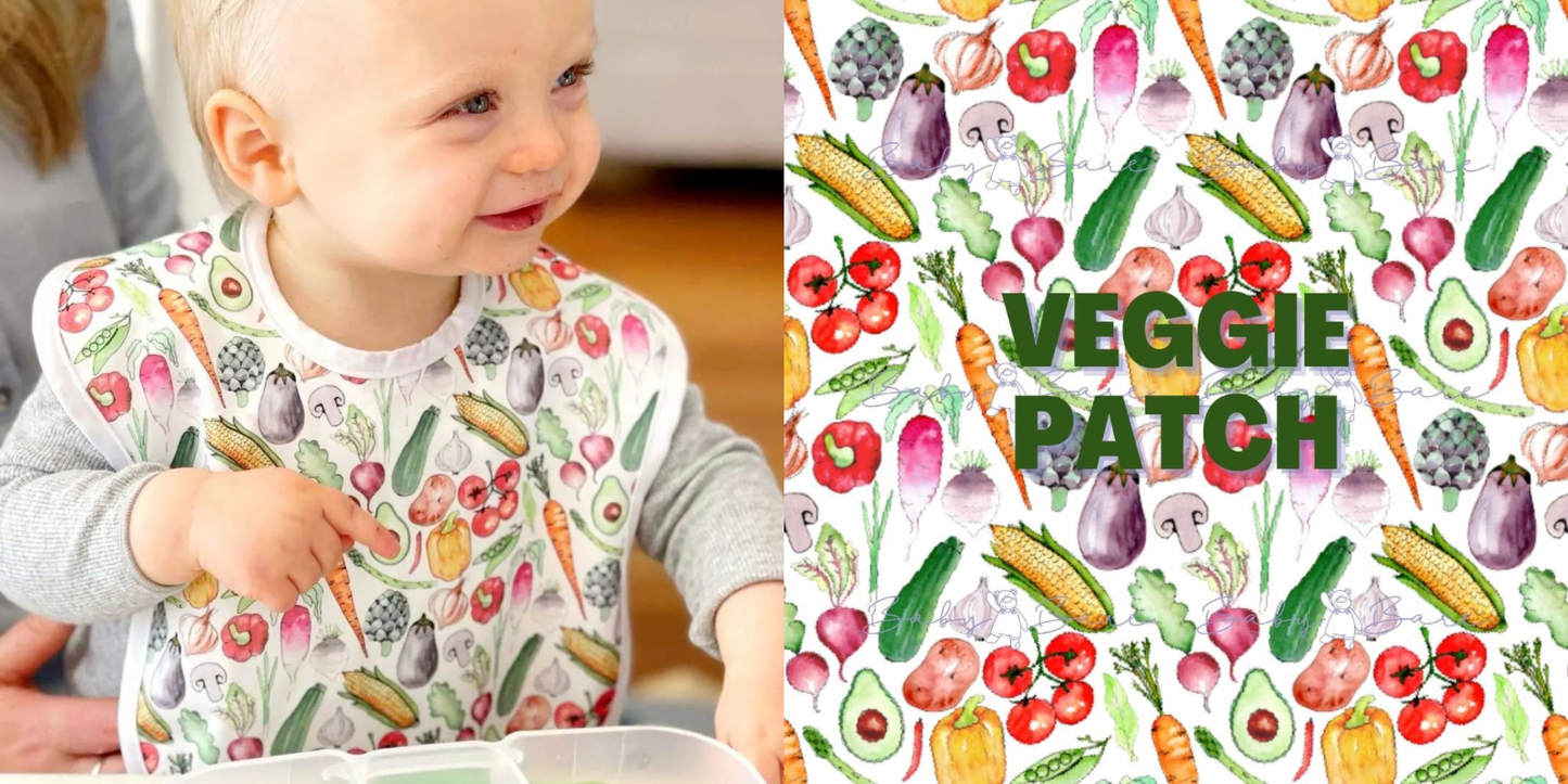Toddler wearing a bib featuring vegetables