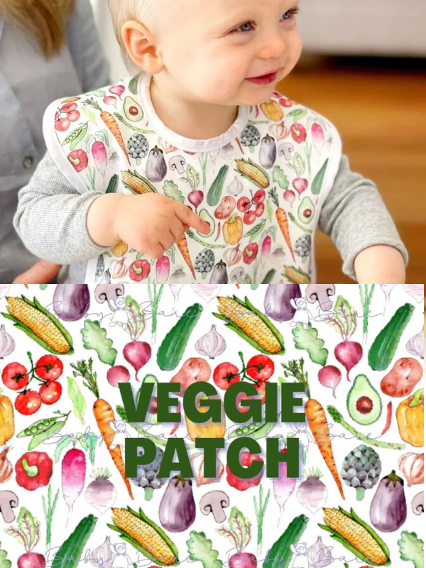 Toddler wearing a bib featuring vegetables