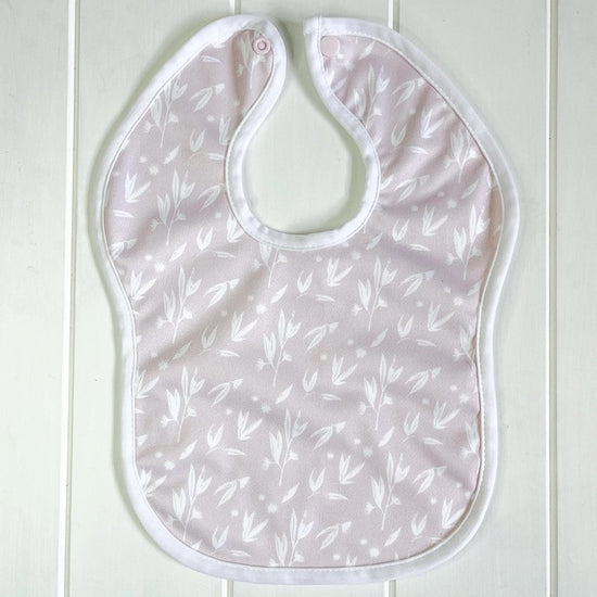 A pink baby bib featuring a blossom print