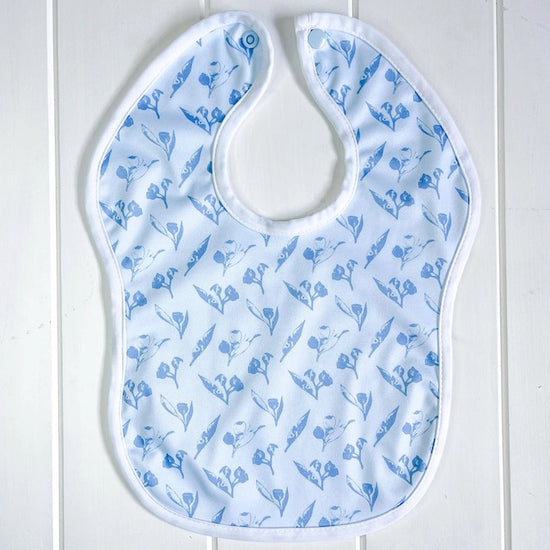 A blue baby bib featuring a gumnuts print