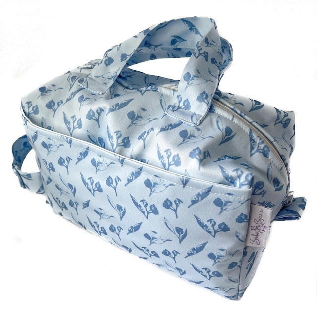 A blue pod style wet bag with a gumnuts design