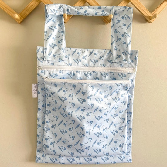 A blue double wet bag with a gumnut design on a hanger