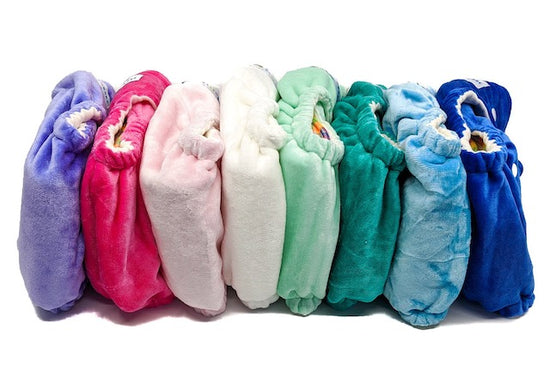 A horizontal stack of colourful cloth night nappies