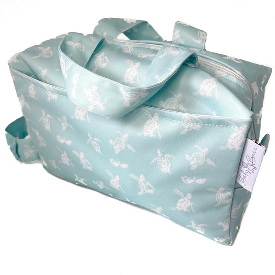 A blue pod style wet bag with a turtle design