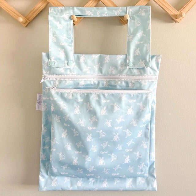 A blue double wet bag with a turtle design on a hanger