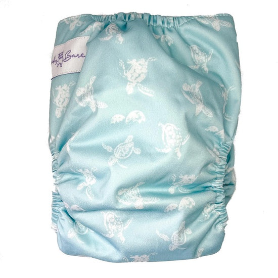 A reusable cloth nappy with a turtle print on a blue base